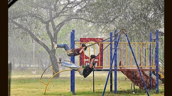 Youngsters making the most of showers at a park in Chandigarh on Friday. Apart from 13.5 mm rain, hail, with 0.8 cm diameter, was also recorded at the Sector 39 IMD observatory. (Ravi Kumar/HT)