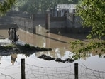 Residents stand near the flooded waters outside their homes following heavy rains in Charsadda district of Khyber Pakhtunkhwa province. (AFP)