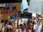 People display placards during a demonstration for a change in the tourism model in the Canary Islands, in Santa Cruz de Tenerife, Spain. 