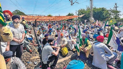 Farmers sit on railway tracks during a protest at the Shambhu border in Patiala. (PTI)