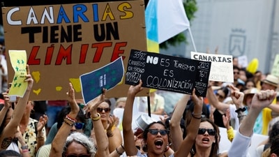 People display placards during a demonstration for a change in the tourism model in the Canary Islands, in Santa Cruz de Tenerife, Spain. (REUTERS/Borja Suarez)