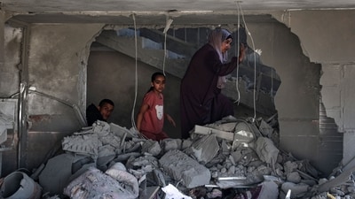 A Palestinian woman and children check the rubble of a building hit by overnight Israeli bombing in Rafah in the southern Gaza Strip (AFP) A Palestinian woman and children check the rubble of a building hit by overnight Israeli bombing in Rafah in the southern Gaza Strip (AFP)