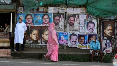 A woman walks past a wall filled with campaign posters of various candidates contesting in India’s parliamentary elections at the Thiruvananthapuram constituency, southern Kerala state, Monday, April 22, 2024. The state goes to polls on April 26. (AP Photo/Manish Swarup) (AP) A woman walks past a wall filled with campaign posters of various candidates contesting in India’s parliamentary elections at the Thiruvananthapuram constituency, southern Kerala state, Monday, April 22, 2024. The state goes to polls on April 26. (AP Photo/Manish Swarup) (AP)