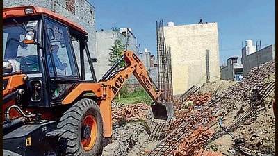 MC officials demolishing illegal buildings at Jassian road in Ludhiana on Monday. (HT Photo)