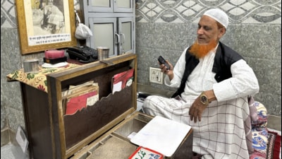 Nabi Ahmad’s modern phone is placed exactly where the old phone was—beside his late brother’s black-and-white portrait. (HT Photo)