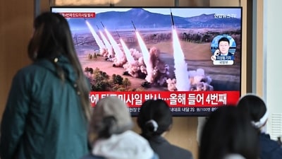 People watch a television screen showing a news broadcast with file footage of a North Korean missile test, at a railway station in Seoul on April 22, 2024. (AFP)