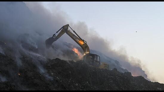 Smoke billows out of the landfill due to the fire on Monday. (PTI)