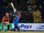 Delhi Capitals' Abishek Porel (R) plays a shot