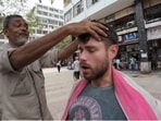 American YouTuber Max McFarlin getting a head massage in Nehru Place from Muhammad Waris. 