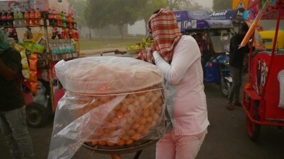 A picture showing a street vendor covering his head as it rains in the national capital. The sudden shift in weather, with the maximum temperature settling at 36.8 degrees Celsius, brought much-needed respite. (HT Photos/Vipin Kumar) A picture showing a street vendor covering his head as it rains in the national capital. The sudden shift in weather, with the maximum temperature settling at 36.8 degrees Celsius, brought much-needed respite. (HT Photos/Vipin Kumar)