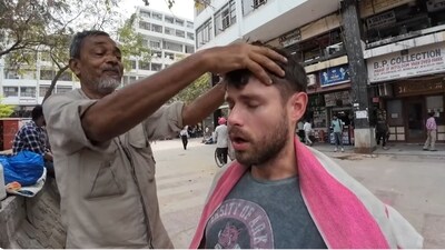 American YouTuber Max McFarlin getting a head massage in Nehru Place from Muhammad Waris. (YouTube/@Daily Max)