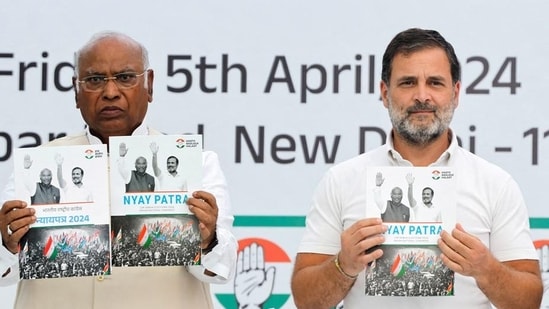 Congress leaders Mallikarjun Kharge and Rahul Gandhi display the party's manifesto for the general election in New Delhi (Reuters file)