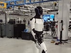 A screenshot of the video showing Optimus robot strolling in the lab. A screenshot of the video showing Optimus robot strolling in the lab.