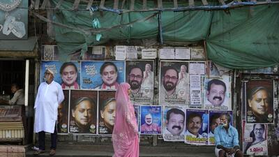 A woman walks past a wall filled with campaign posters of various candidates contesting in India’s parliamentary elections at the Thiruvananthapuram constituency (AP) A woman walks past a wall filled with campaign posters of various candidates contesting in India’s parliamentary elections at the Thiruvananthapuram constituency (AP)