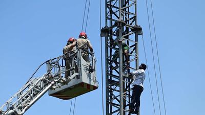 Firemen pull down protesters from a mobile tower near Jantar Mantar. (Vipin Kumar/HT Photo)