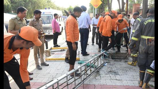 Rescuers at Lucknow’s Jankipuram where an 8-year-old boy died after falling into an open manhole on Tuesday. (HT Photo)