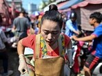 A vendor sweats from the heat as she pulls a cart at Khlong Toei Market, the biggest fresh market in Bangkok.