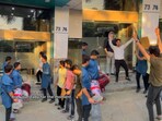 Man and his friends dancing outside his office. 