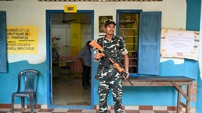 A security personnel stands guard at a polling station in Wayanad district (AFP) A security personnel stands guard at a polling station in Wayanad district (AFP)