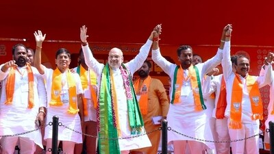 inister Amit Shah and BJP Medak candidate, Raghunandan Rao hold hands during a public meeting, in Medak on Thursday (Amit Shah-Xm) inister Amit Shah and BJP Medak candidate, Raghunandan Rao hold hands during a public meeting, in Medak on Thursday (Amit Shah-Xm)