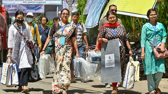 Women poll officers with EVMs leave for their duty, at Balurghat, in South Dinajpur district of West Bengal.(PTI)