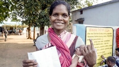 A woman carrying an infant shows her ink-marked finger at a polling station, in Mahasamund, Chhattisgarh. (ANI) A woman carrying an infant shows her ink-marked finger at a polling station, in Mahasamund, Chhattisgarh. (ANI)