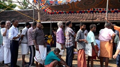 A man squats to rest as he waits with others in a queue to vote during elections in Kerala. A man squats to rest as he waits with others in a queue to vote during elections in Kerala.