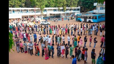 People wait in queues to cast their votes at a polling station at Rajarajeshwari Nagar, in Bengaluru, on Friday. (PTI) People wait in queues to cast their votes at a polling station at Rajarajeshwari Nagar, in Bengaluru, on Friday. (PTI)