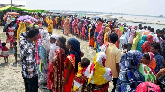Voters stand in queues to cast their votes during 2nd phase of voting for Lok Sabha polls, at Gashbari, Darrang district of Assam on Friday. (ANI Photo)
