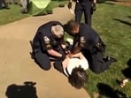 Two Georgia State police officers are trying to handcuff an Emory University professor. Two Georgia State police officers are trying to handcuff an Emory University professor.