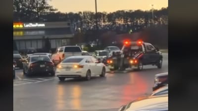 Picture shows a woman dodging tow truck in a jacked parking lot (TikTok/hoodlum) Picture shows a woman dodging tow truck in a jacked parking lot (TikTok/hoodlum)