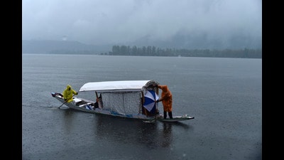 A boatman rows a boat during rain in Srinagar on Saturday. (Waseem Andrabi/HT) A boatman rows a boat during rain in Srinagar on Saturday. (Waseem Andrabi/HT)