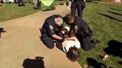 Two Georgia State police officers are trying to handcuff an Emory University professor. Two Georgia State police officers are trying to handcuff an Emory University professor.