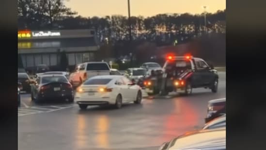 Picture shows a woman dodging tow truck in a jacked parking lot (TikTok/hoodlum)