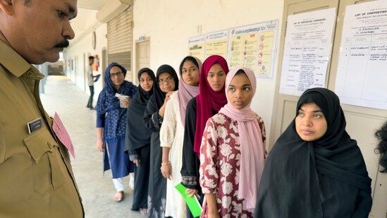 A policeman stands guard as people queue up to vote during the second round of voting in the six-week long national election outside a polling booth in Kochi, southern Kerala state, India, Friday, April 26, 2024. (AP Photo/R S Iyer) (AP)