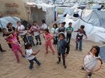 Palestinian children play with hula hoops near makeshift tent camp as schools remain closed due to Israel's military offensive, amid the ongoing conflict between Israel and the Palestinian Islamist group Hamas, in Deir Al-Balah in the central Gaza Strip April 28, 2024. REUTERS/Ramadan Abed