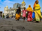 Pedestrians cross a road with its tarmac melting due to heat wave, in Esplanade area, in Kolkata, on Sunday. (PTI)