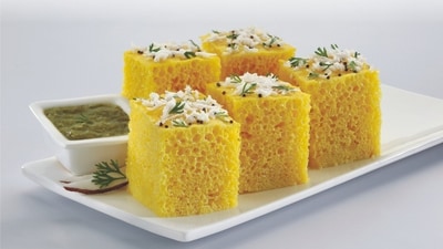 Dhokla (Gujarat): A light and fluffy snack from Gujarat, Dhokla is a steamed savoury cake made from fermented rice and chickpea flour, seasoned with mustard seeds and curry leaves. It is typically served with a drizzle of tempered oil and fresh coriander. (Pinterest) Dhokla (Gujarat): A light and fluffy snack from Gujarat, Dhokla is a steamed savoury cake made from fermented rice and chickpea flour, seasoned with mustard seeds and curry leaves. It is typically served with a drizzle of tempered oil and fresh coriander. (Pinterest)