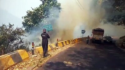 Nainital, Apr 27 (ANI): A firefighter attempts to control the fire caught in the forest in Nainital on Saturday. (ANI Photo) (ANI)