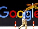 Google layoffs: A man walks past a logo of Alphabet Inc's Google in front of an office building in Zurich, Switzerland.