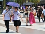 Pedestrians shield themselves from the sun with umbrellas to combat the heat outside Siam Paragon shopping mall in Bangkok . Pedestrians shield themselves from the sun with umbrellas to combat the heat outside Siam Paragon shopping mall in Bangkok .
