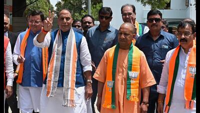 Accompanied by UP chief minister Yogi Adityanath and his Uttarakhand counterpart Pushkar Singh Dhami, the defence minister reached the collectorate for filing nomination papers. (HT Photo)