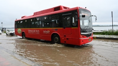 Vehicles drive through the water logging Boulevard road on the banks of Dal Lake in Srinaga. (HT Photo/Waseem Andrabi)