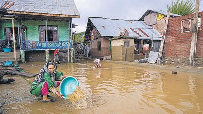 A woman removes standing water from her partially submerged house as flood water recedes at Chogal Handwara, in Kupwara district of North Kashmir, on Tuesday. (PTI) A woman removes standing water from her partially submerged house as flood water recedes at Chogal Handwara, in Kupwara district of North Kashmir, on Tuesday. (PTI)