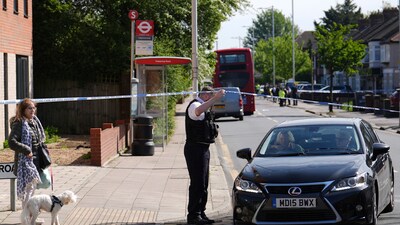 Police talking to members of the public at the scene in Hainault, north east London. (AP) Police talking to members of the public at the scene in Hainault, north east London. (AP)