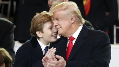 President Donald Trump, right, smiles with his son Barron as they view the 58th Presidential Inauguration parade for President Donald Trump in Washington on Jan 20. (AP Photo)