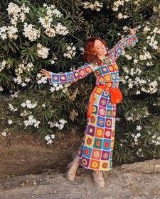 A Coachella attendee in a multi-coloured crocheted dress accessorised with an orange fanny pack (Photo: Instagram)