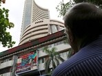 Stock market holiday today: A man looks at a screen across a road displaying the Sensex on the facade of the Bombay Stock Exchange (BSE) building in Mumbai.