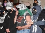 Pro-Palestinian student protesters lock arms at the entrance to Hamilton Hall on the campus of Columbia University, on April 30, 2024, in New York City. Dozens of helmeted police flooded Columbia University's campus in the heart of New York City on April 30, 2024 to evict a building occupied by pro-Palestinian student protesters and detain demonstrators. Police climbed into Hamilton Hall via a second floor window they reached from a laddered truck, before leading handcuffed students out of the building into police vans. (Photo by Julia Wu / AFP) Pro-Palestinian student protesters lock arms at the entrance to Hamilton Hall on the campus of Columbia University, on April 30, 2024, in New York City. Dozens of helmeted police flooded Columbia University's campus in the heart of New York City on April 30, 2024 to evict a building occupied by pro-Palestinian student protesters and detain demonstrators. Police climbed into Hamilton Hall via a second floor window they reached from a laddered truck, before leading handcuffed students out of the building into police vans. (Photo by Julia Wu / AFP)
