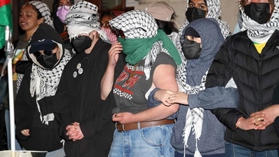 Pro-Palestinian student protesters lock arms at the entrance to Hamilton Hall on the campus of Columbia University, on April 30, 2024, in New York City. Dozens of helmeted police flooded Columbia University's campus in the heart of New York City on April 30, 2024 to evict a building occupied by pro-Palestinian student protesters and detain demonstrators. Police climbed into Hamilton Hall via a second floor window they reached from a laddered truck, before leading handcuffed students out of the building into police vans. (Photo by Julia Wu / AFP) (AFP)